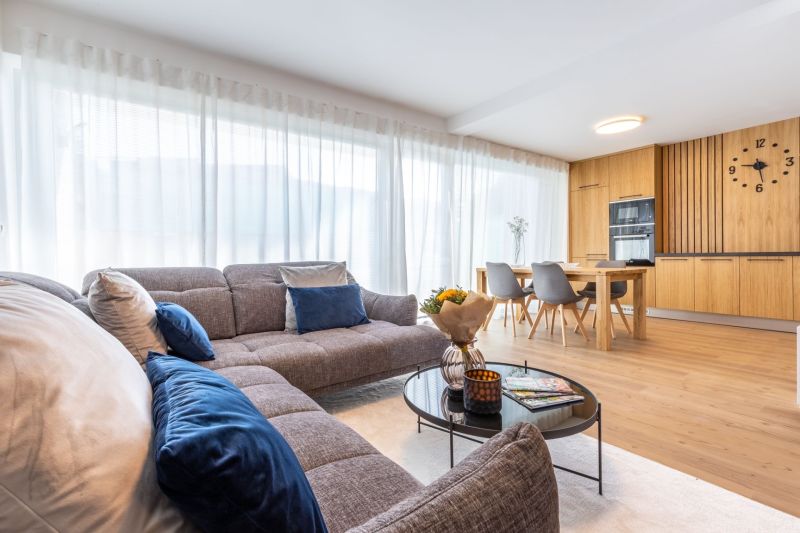 Wohnzimmer in einem Einfamilienhaus mit Sofa, Esstisch und Holzboden.