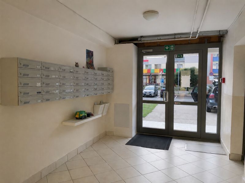 Eingangsbereich einer 3-Zimmer-Wohnung mit Briefkästen und Glastüren.