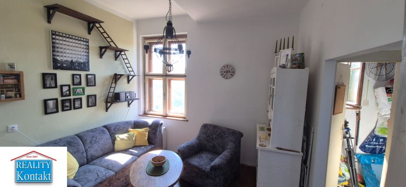 Wohnzimmer in einer Zweizimmerwohnung mit einem bequemen Sofa und Wanddekorationen.