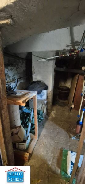 Kellerraum in einer 2-Zimmer-Wohnung mit Lagerregalen und Rohrleitungen.
