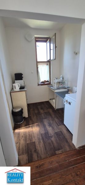 Küche in einer 2-Zimmer-Wohnung mit Holzboden und einfacher Ausstattung.