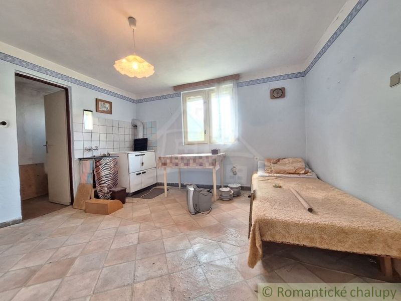 In einem Einfamilienhaus gibt es ein einfaches Zimmer mit einer Kochnische und einem Sessel.