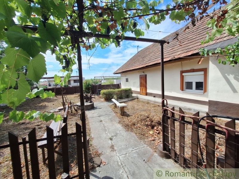 Der Hof beim Einfamilienhaus in Kamenica nad Hronom mit einer Pergola und einer Bank.