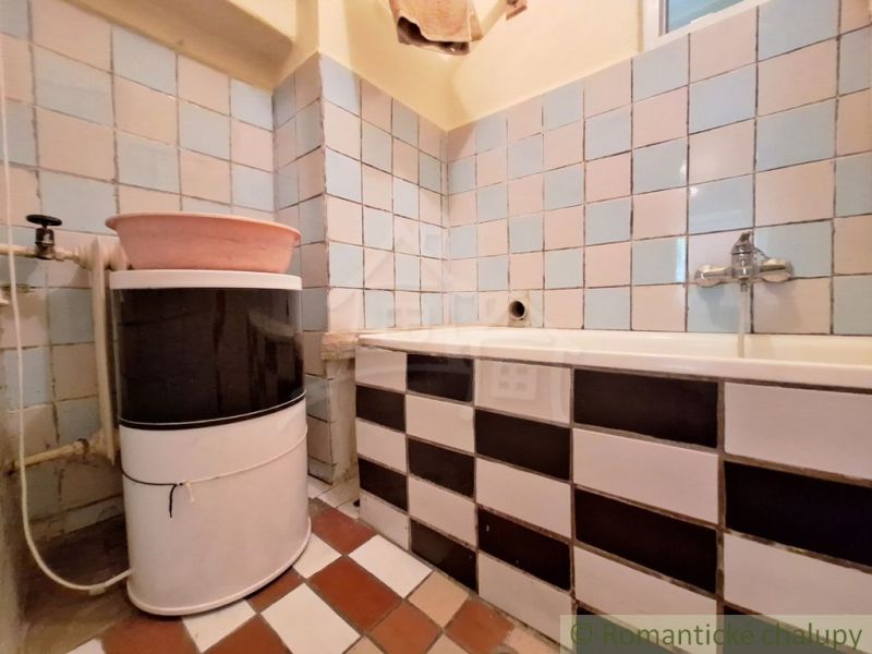Badezimmer in einem Einfamilienhaus mit Waschbecken und Badewanne, gefliest.