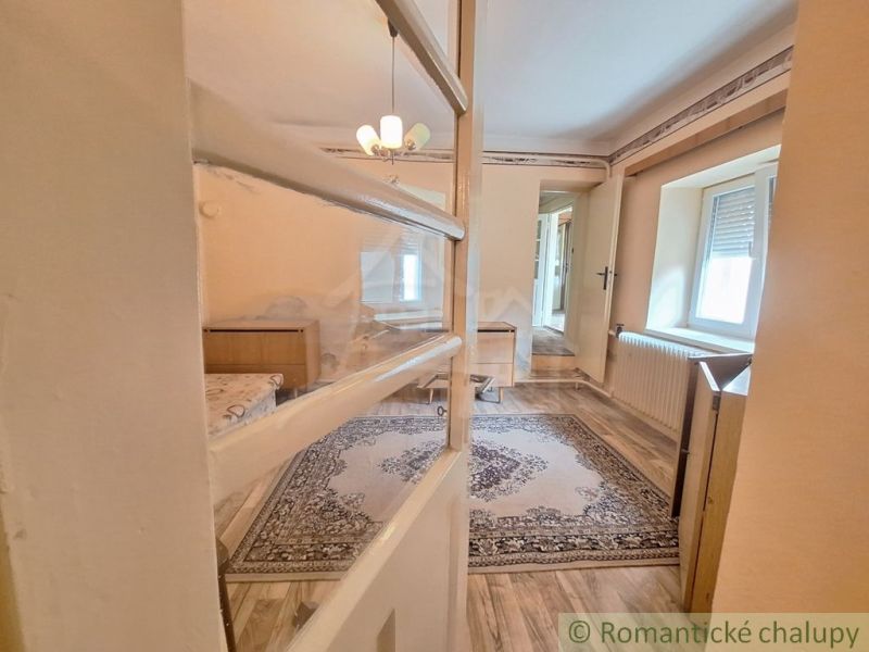 Innenraum eines Einfamilienhauses mit Holzboden, Teppich und Kronleuchter.