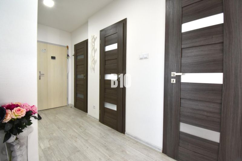 Flur mit Türen und Holzboden in einer 3-Zimmer-Wohnung.