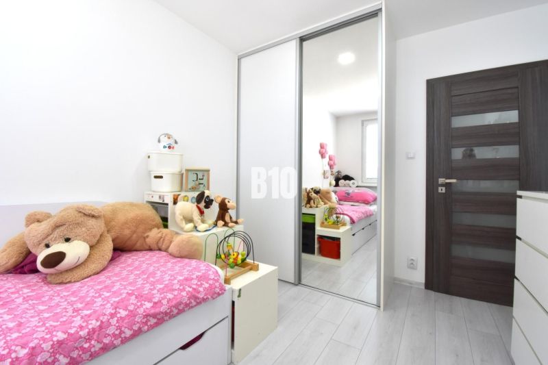 Kinderzimmer in einer 3-Zimmer-Wohnung mit Bett, Plüschtieren und Boden in Holzoptik.