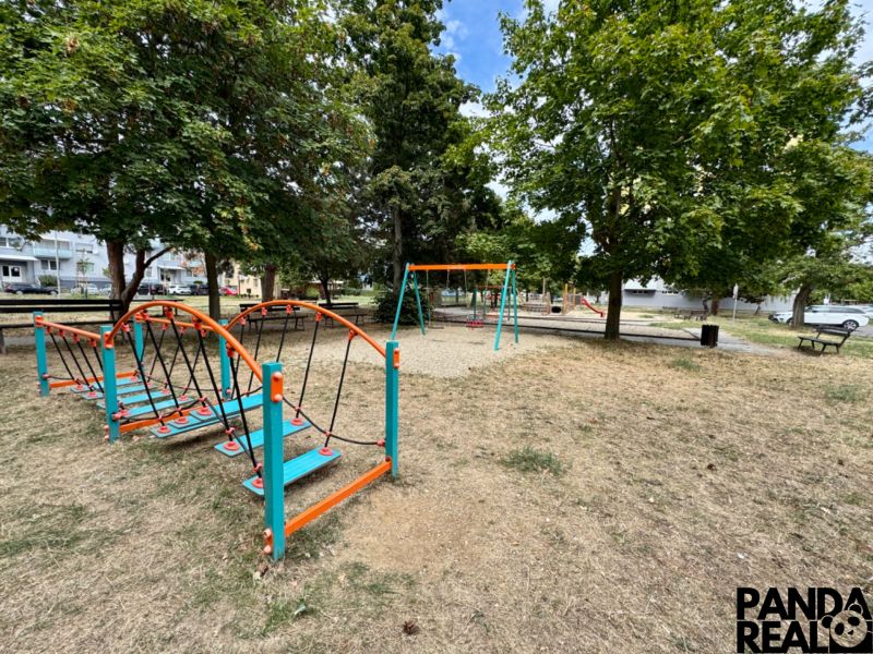 Spielplatz in Topoľčany mit verschiedenen Attraktionen und Bänken im Park.