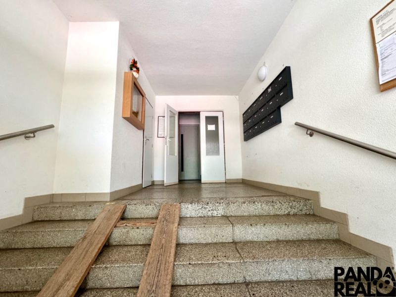 Eingangshalle in einem Wohnhaus mit Briefkästen und Aufzug.