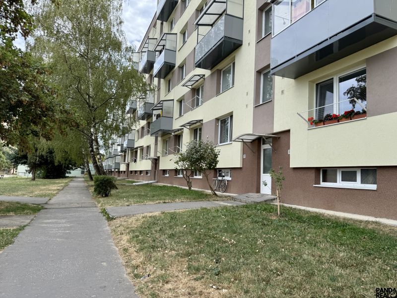 Ein Wohnhaus mit Grünflächen und einem Gehweg, gelegen in Topoľčany, umgeben von Bäumen.
