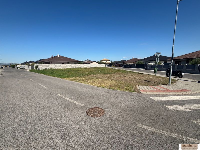Ein Baugrundstück in Most pri Bratislave, umgeben von Straßen und neuen Gebäuden.
