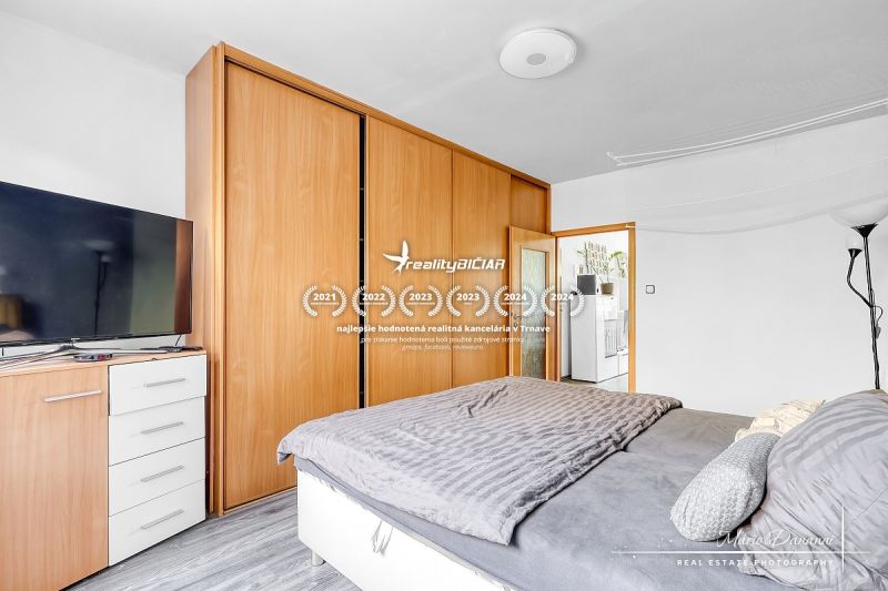 Schlafzimmer in einer 2-Zimmer-Wohnung mit Holzboden und Einbauschrank.