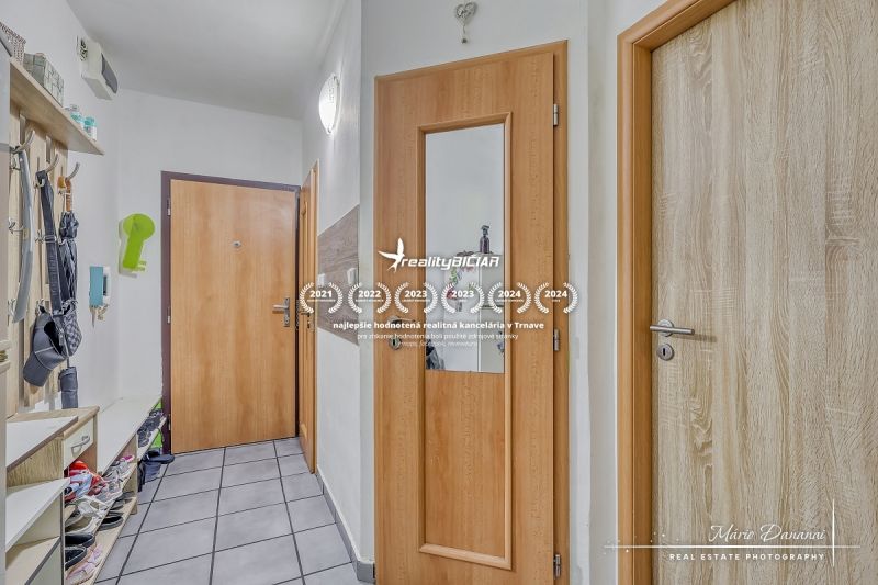 Flur in einer 2-Zimmer-Wohnung mit Fliesenboden und Holztüren.