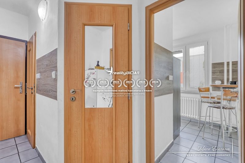 Innenraum einer 2-Zimmer-Wohnung mit Holztüren und verglastem Eingang zur Küche.