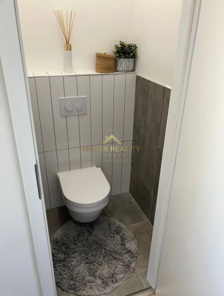 Badezimmer in einer 3-Zimmer-Wohnung mit Stauraum und Dekoration auf dem Regal.