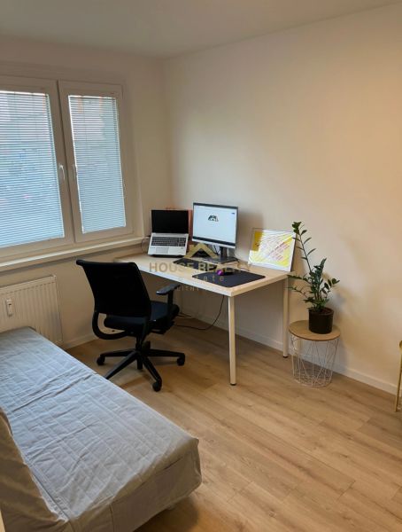 Ein Arbeitsbereich in einer 3-Zimmer-Wohnung mit Holzboden und ausziehbarem Sofa.