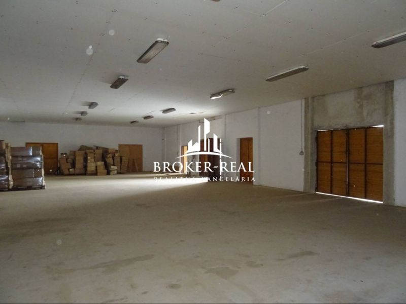 Lagerhäuser und Hallen mit Paketen und Verpackungen auf dem Boden, Holztüren, Beleuchtung von der Decke.