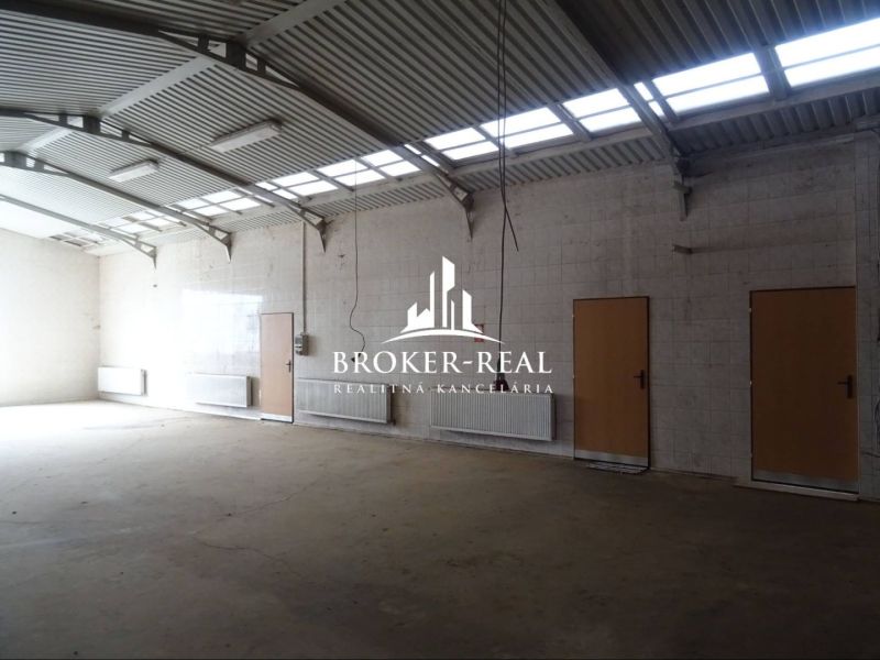Ein Raum mit hoher Decke und viel natürlichem Licht in einem Gebäude mit Lagern und Hallen.