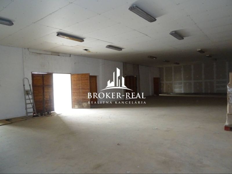 Ein geräumiger Saal innerhalb von Lagern und Hallen mit Betonboden und Beleuchtung.