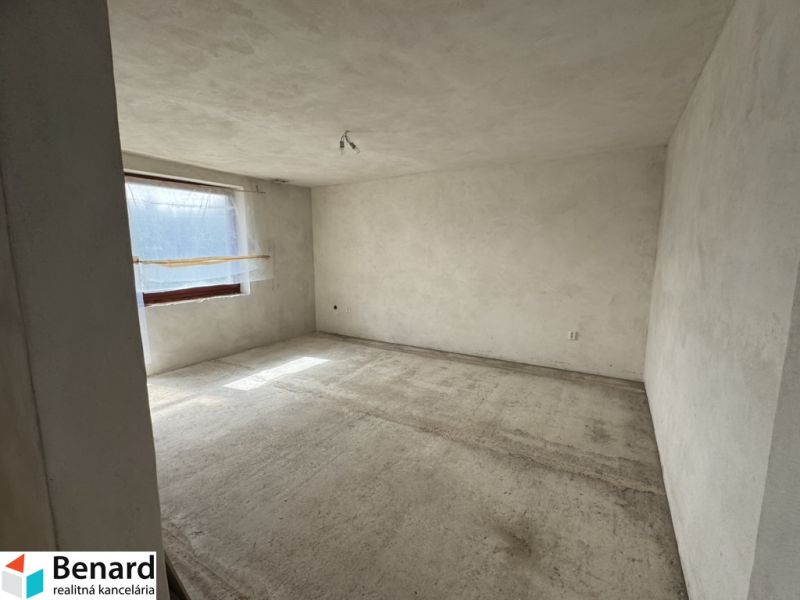 Prázdna miestnosť v rodinnom dome s oknom, betónovou podlahou a bielymi stenami.

Leerer Raum in einem Einfamilienhaus mit Fenster, Betonboden und weißen Wänden.