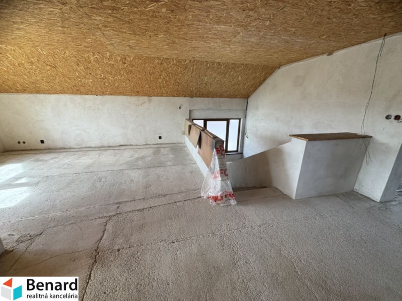 Dachboden eines Einfamilienhauses mit Holzbalkendecke und Blick auf das Innere der Treppe.