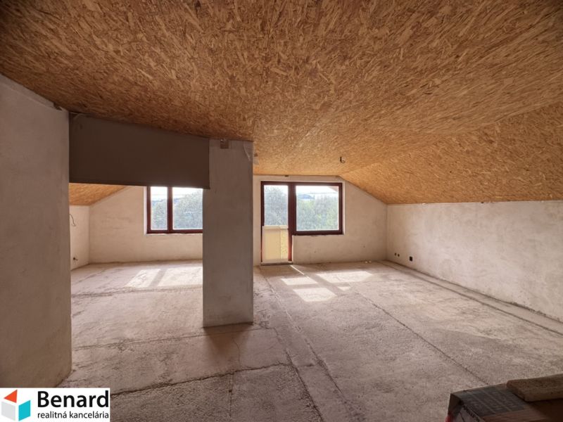 Dachbodenraum in einem Einfamilienhaus mit großen Fenstern und Aussicht.