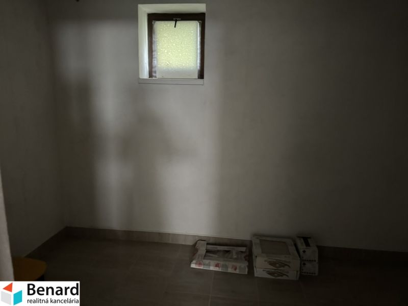 Dachzimmer in einem Einfamilienhaus mit Kisten und kleinem Fenster.