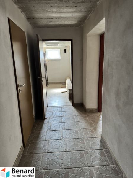 Flur in einem Einfamilienhaus mit Fliesen und Fenster, ohne sichtbare Möbel.