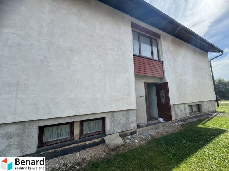 Ein Einfamilienhaus in Plavnica mit hellem Putz und Holzfenstern im Erdgeschoss.