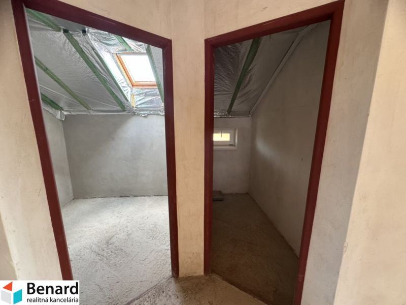 Dachbodenräume eines Einfamilienhauses mit doppeltem Eingang, Dachfenster und unvollendeten Wänden.