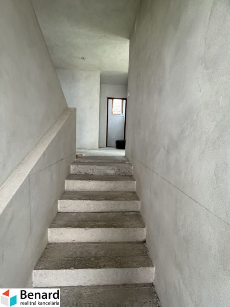 Betontreppen, die in einem Einfamilienhaus in den ersten Stock führen, mit verputzten Wänden.