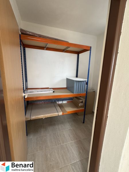 Stauraum im Einfamilienhaus mit einem Regal und einem Bodenbelag in Holzoptik.