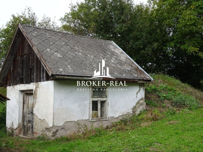 Ein kleines Familienhaus in Černochov mit einem Holzdach und einer vernachlässigten Fassade.
