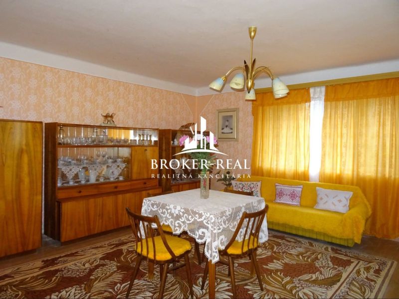 Wohnzimmer in einem Einfamilienhaus mit Retro-Möbeln und gelben Vorhängen.