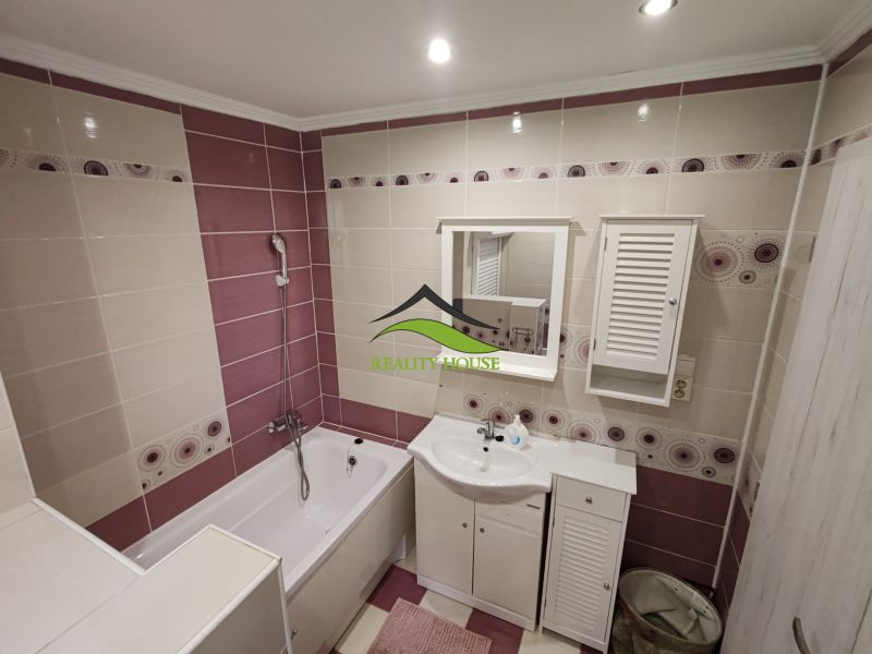 Badezimmer mit Duschwanne und weißen Möbeln in einer 3-Zimmer-Wohnung.