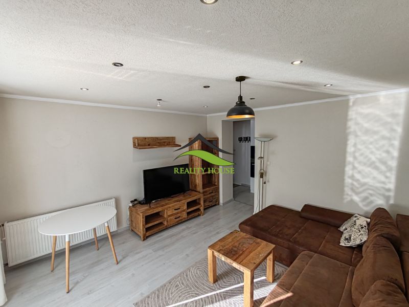 Wohnzimmer in einer 3-Zimmer-Wohnung mit Sofa und Holzmöbeldekor.