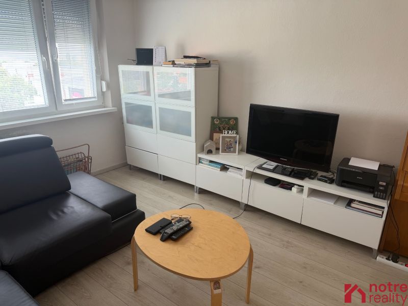 Wohnzimmer in einer 2-Zimmer-Wohnung mit Holzboden und modernen Möbeln.