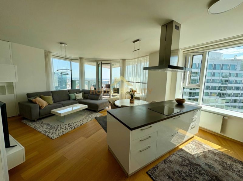 Helles Wohnzimmer mit Holzboden in einer 3-Zimmer-Wohnung, mit Blick aus großen Fenstern.