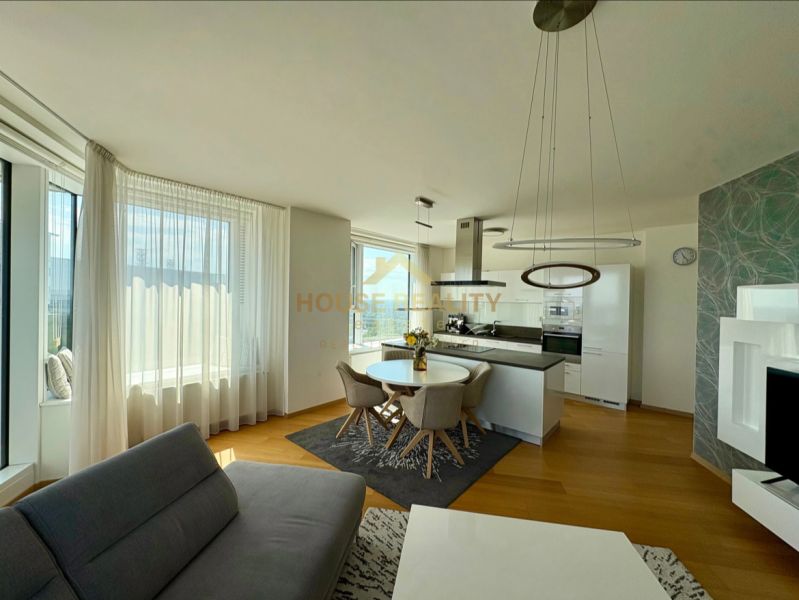 Wohnzimmer einer 3-Zimmer-Wohnung mit Holzboden und Kochnische.