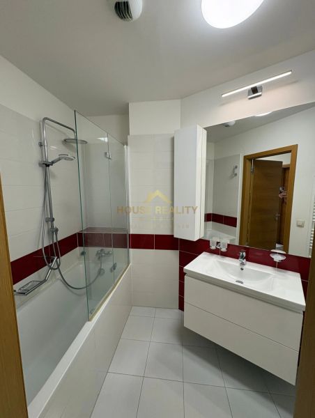 Badezimmer mit Badewanne, Spiegel und Waschbecken in einer 3-Zimmer-Wohnung.
