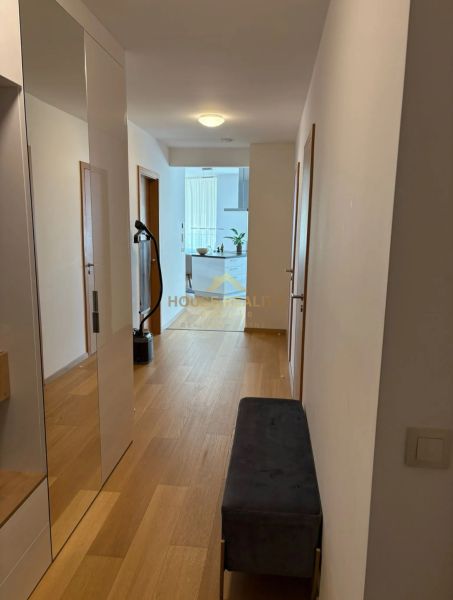 Flur mit Holzboden und Spiegel in einer 3-Zimmer-Wohnung.