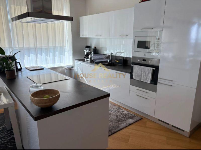 Küche in einer 3-Zimmer-Wohnung mit weißen Schränken und einem Boden in Holzoptik.