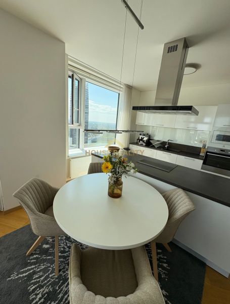 Küche in einer 3-Zimmer-Wohnung mit rundem Tisch und Aussicht, Boden mit Holzdekor.