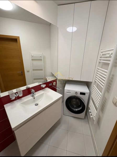 Badezimmer in einer 3-Zimmer-Wohnung mit Waschmaschine, Waschbecken und Stauraum.