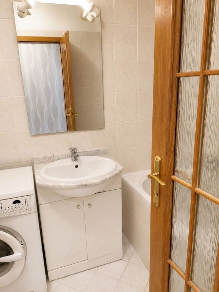 Badezimmer in einer 2-Zimmer-Wohnung mit Waschmaschine, Waschbecken und Badewanne.