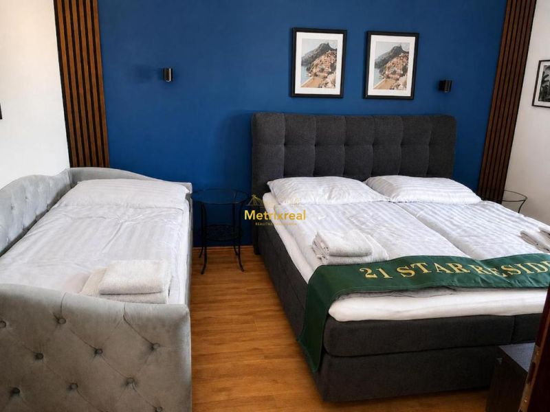 Schlafzimmer mit Doppelbett, blauer Wand und Holzboden.