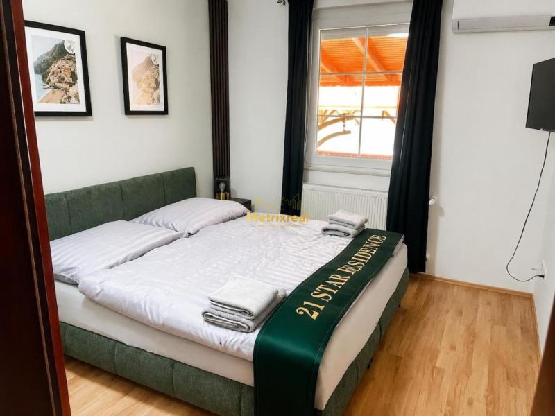 Schlafzimmer mit Doppelbett, Holzboden, Wanddekorationen.