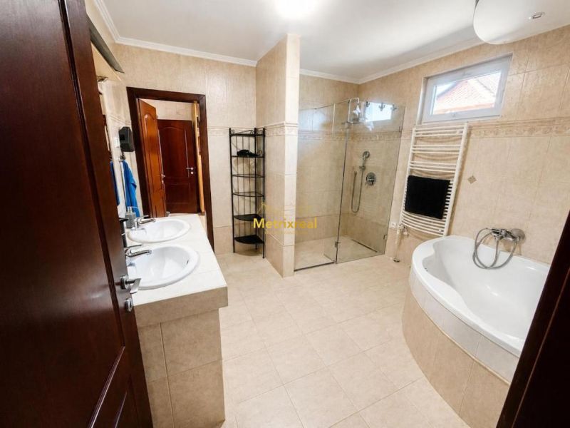 Badezimmer im Einfamilienhaus mit Doppelwaschbecken, Dusche und Badewanne.