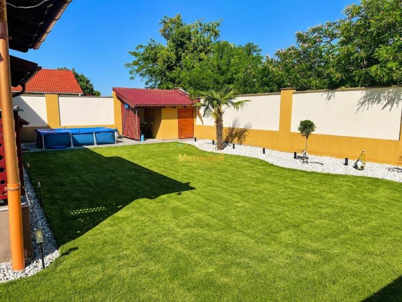 Der Garten eines Einfamilienhauses in Darnózseli mit einem Pool und einem sorgfältig gepflegten Rasen.