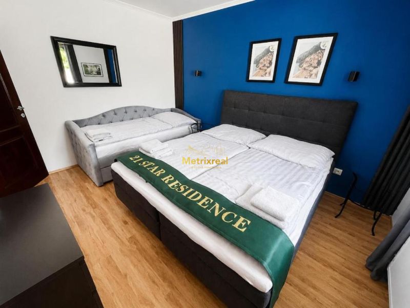 Ein Schlafzimmer in einem Einfamilienhaus mit einem Holzboden und einer dunkelblauen Wand.